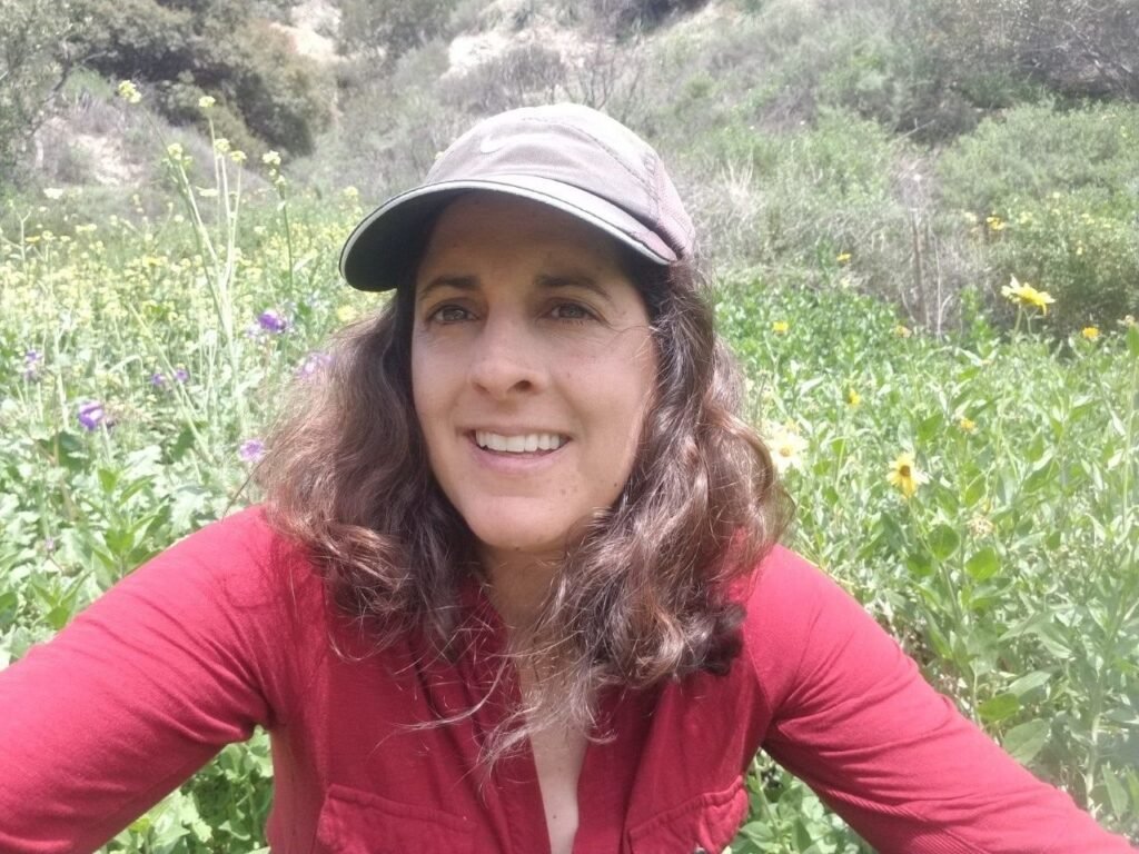 woman-with-basebal-cap-sitting-in-a-flower-field